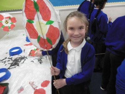 school girl holding st. georges day art work with red rose associated with England