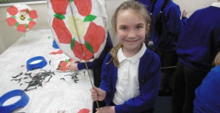 school girl holding st. georges day art work with red rose associated with England